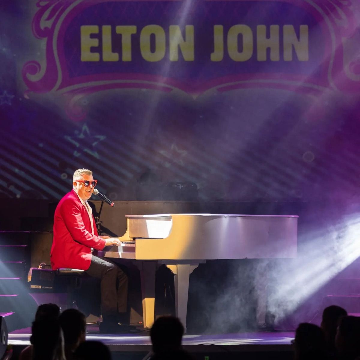 Evan in a red jacket at the piano
